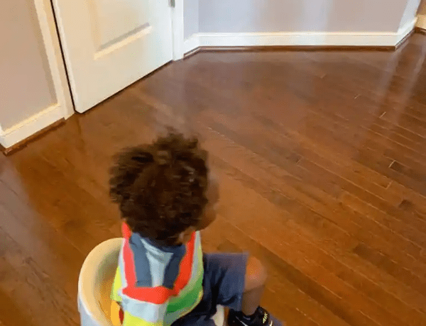 Toddler sitting on potty chair for potty training.