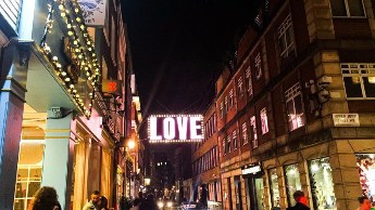 Love sign hanging in the streets of London at night.