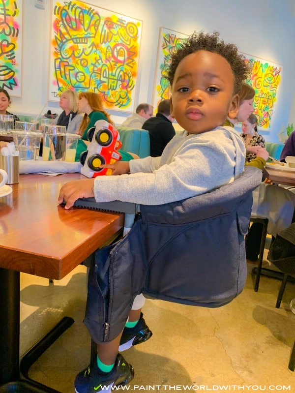 Toddler sitting in the Inglesina high chair at a restaurant