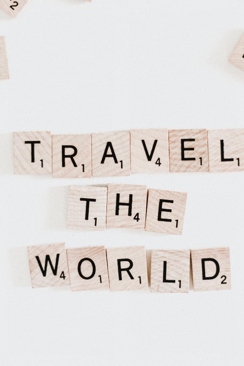 Black letters on wooden blocks that spell out Travel The World